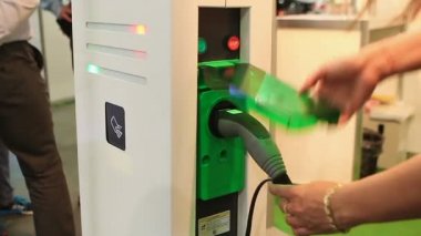 Elektrikli araçlar için kadın el testi şarj noktası, stop düğmesine basarak
