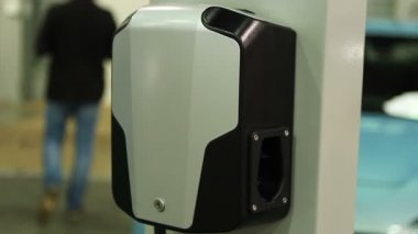 Şarj istasyonunda elektrikli araç fişini bağlayan ve kesen kişi