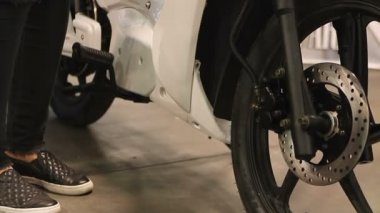 Showroom, gelecekteki taşıma, elektrikli scooter tarafından duran genç kişi metrelik
