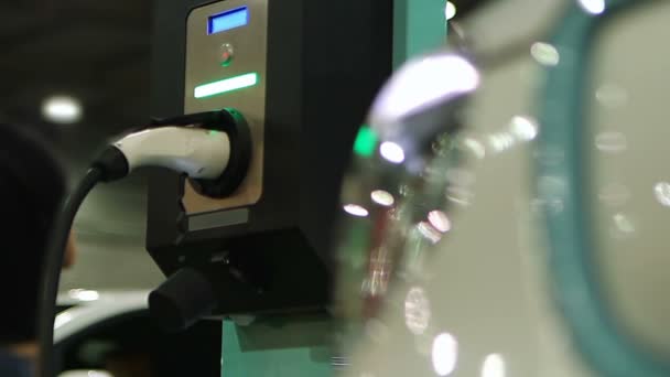 Moderní elektrické vozidlo připojeno k síti prostřednictvím zástrčky na veřejnou dobíjecí stanici — Stock video