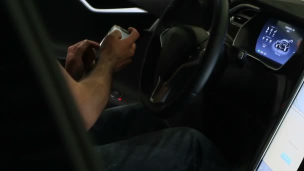 Hombre usando el teléfono inteligente y el panel de pantalla táctil del coche eléctrico moderno — Vídeo de stock