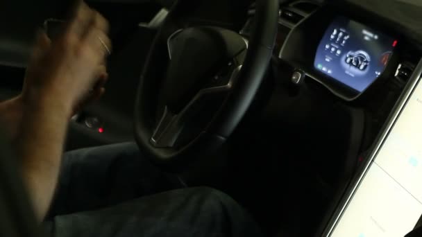 Manos masculinas conectar el teléfono inteligente al sistema de control de pantalla táctil coche eléctrico — Vídeos de Stock