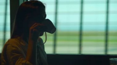 Havaalanında kahve içme ve onun uçak için bekleyen düşünceli erkek