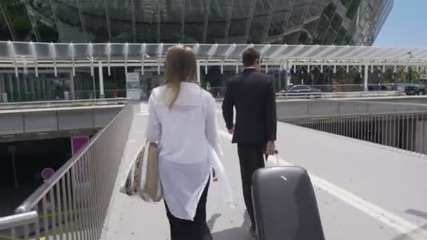 Glamouröse Frau und Leibwächter mit ihrem Gepäck zu Fuß am Flughafen, Tourismus — Stockvideo