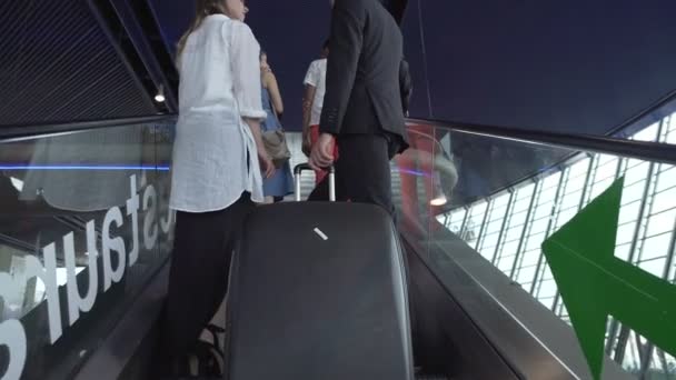 Деловая поездка, прибытие партнеров на конференцию, перемещение по эскалатору в аэропорту — стоковое видео