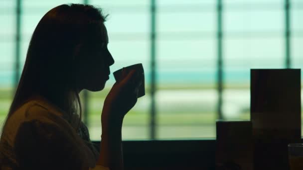 Mooie vrouw vliegtuig in luchthaven restaurant wachten en koffie drinken — Stockvideo