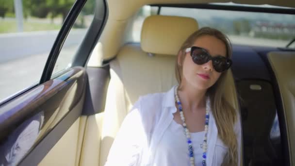 Blonde žena těší výlet na zadní sedadlo drahé auto, cestovní ruch — Stock video