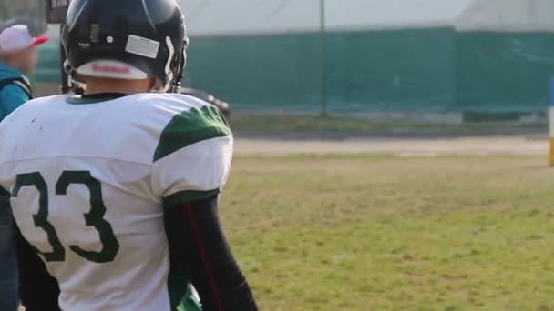 Anxious American football player waiting substitution on field, watching match — Stock Video