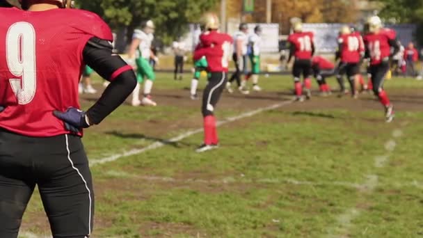 Игроки соперничающей футбольной команды занимают позиции на линии схватки перед щелчком — стоковое видео