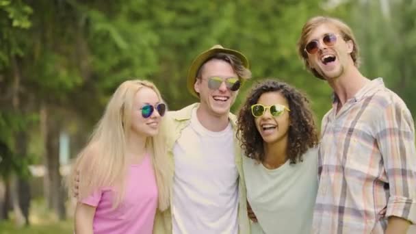 Mladí přátelé radostné srandu a směje se, mít dobrý víkend v parku, relaxovat — Stock video