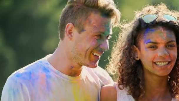 Positieve emoties van happy mannelijke en vrouwelijke vrienden knuffelen op kleur festival — Stockvideo