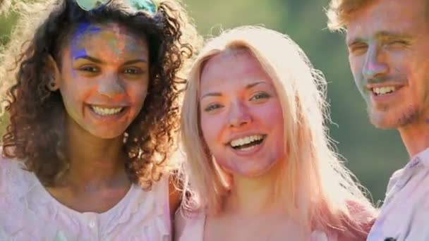 Веселые улыбающиеся лица молодых людей, веселящихся на фестивале в Холи — стоковое видео