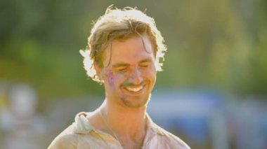 Mutlu genç adam altın güneş altında dans, kız sürpriz sırtına atlama