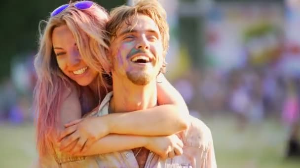 Glücklicher junger Mann trägt schöne Freundin auf dem Rücken, fröhliches Paar umarmt — Stockvideo
