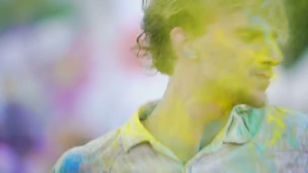 空気中に色の粉を投げる興奮陽気な男によって行われるクレイジーダンス — ストック動画