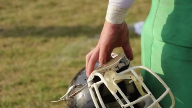 Kask holding, Amerikan futbolu oyunu izlerken, değişimi için bekleyen oyuncu