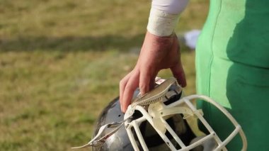 Kask holding, Amerikan futbolu oyunu izlerken, değişimi için bekleyen oyuncu