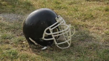 Spor sahası, Amerikan futbolu oyunu, sembolü çimlere yatan siyah kask