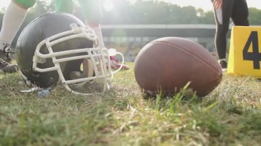 Eğitim bir güneşli gün, kask ve topu closeup Amerikan futbol oyuncuları