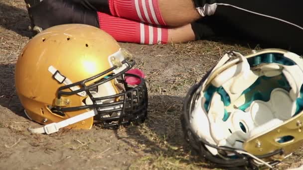 Joueur de football fatigué assis sur le sol et se détendre après un match difficile — Video