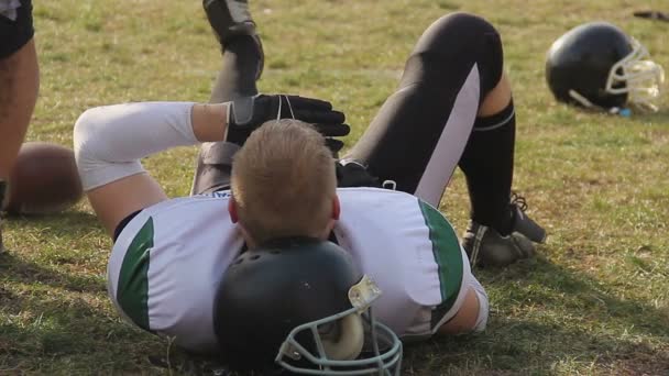 Ленивый футболист лежит на поле и расслабляется, тайм-аут во время сложной игры — стоковое видео