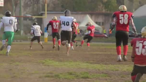 Mariscal de campo corriendo a la zona de anotación y se enfrenta, partido de fútbol en la ciudad pequeña — Vídeos de Stock