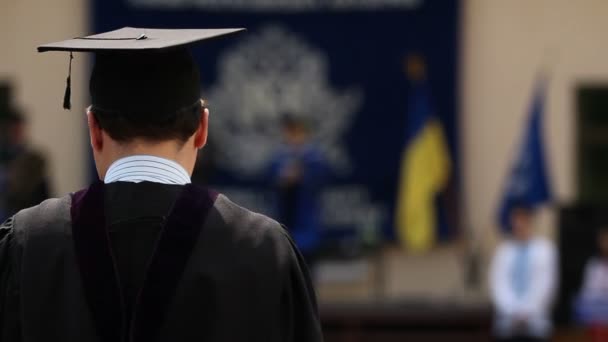 Man in academische jurk enthousiast over het behalen van diploma bij graduatie ceremonie — Stockvideo