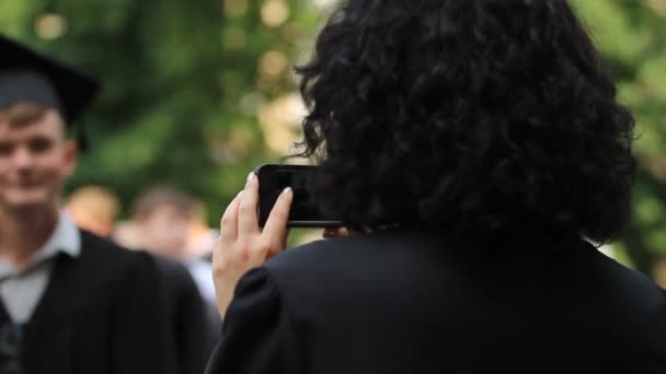 Madre tomando fotos de su hijo graduándose de la universidad en el teléfono inteligente, la vida feliz — Vídeo de stock