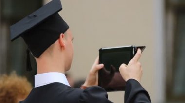 Akademik elbise alarak resim modern tablet Pc in üniversite öğrencisi mezun