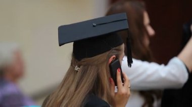 Genç kadın konuşurken telefonla, tebrikler mezuniyet üzerinde akademik şapkalı