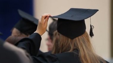 Genç kadın ayarlama akademik kapakta baş, öğrencileri mezuniyet için hazır.