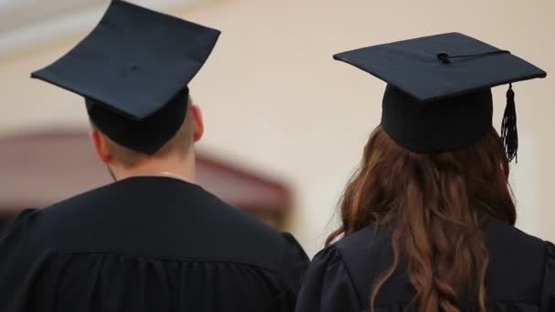 Casal feliz de estudantes graduados no amor que recebe diplomas na cerimônia — Vídeo de Stock