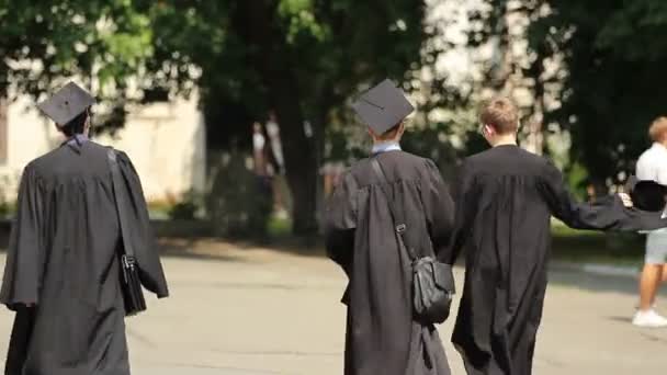 Hombres jóvenes que abandonan el patio de la universidad después de la ceremonia de graduación, futuro exitoso — Vídeos de Stock