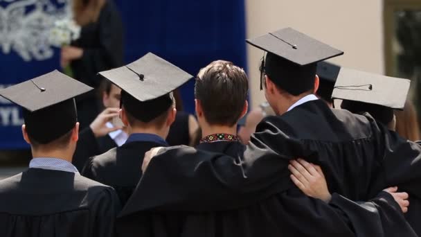 Amigos de la universidad abrazando, posando para la foto juntos, ceremonia de graduación — Vídeo de stock