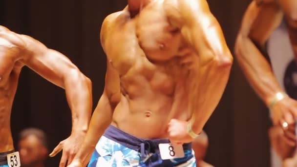 Professionelle Bodybuilder posieren auf der Bühne bei sportlichen Wettkämpfen, Sport — Stockvideo