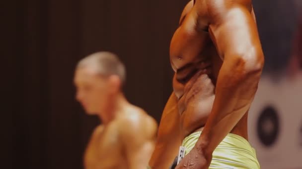 Спортсмен, що демонструє розірвані м'язи тулуба на професійному змаганні з бодібілдингу — стокове відео