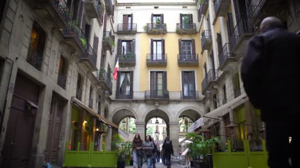 BARCELONA, ESPAÑA - CIRCA ENERO 2016: Turistas en un tour turístico. Acogedora calle en la tranquila ciudad europea, muchas personas ocupadas caminando por cafés al aire libre — Vídeos de Stock