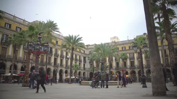 Barcelona, Spanyolország - körülbelül 2016. január: Turisták egy városnéző túra. Barcelona-turisták jelentenek, szökőkút, city Square, Spanyolország közelében Royal Plaza — Stock videók