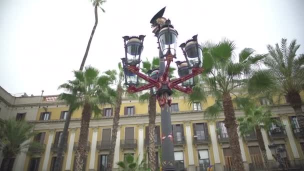 Barcelona, Spanien - Circa januari 2016: Turister på en sightseeingtur. Plaza Real lykta designad av spanska arkitekten Gaudi, resa till Barcelona, Spanien — Stockvideo