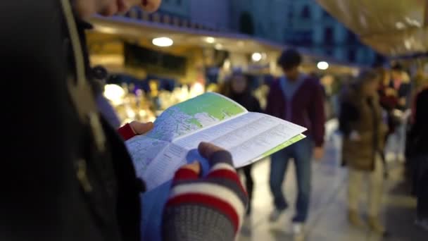 Viajero sosteniendo el mapa de la ciudad en las manos, mirando tiendas de recuerdos, comprobando la ruta — Vídeo de stock