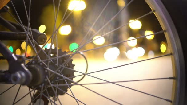 Defocused silhouettes of people walking city street, view through bicycle wheel — Stock Video