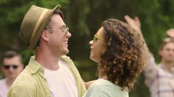 Flirty jonge man en vrouw knuffelen en genieten van dansmuziek op zomer feest — Stockvideo