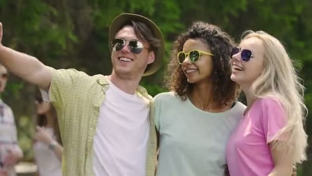 Veselá mladých lidí, objímání a tanec, pózuje pro selfie na letní párty — Stock video