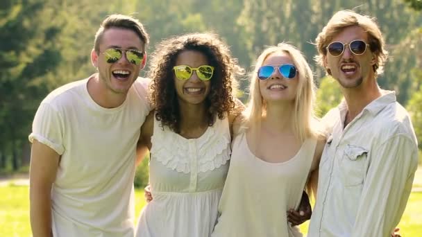 Grupo multiétnico de personas en gafas de sol sonriendo alegremente, agitando las manos — Vídeos de Stock