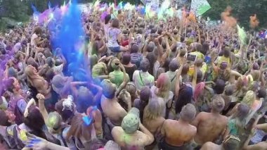 Kalabalık boya toz havada atar.