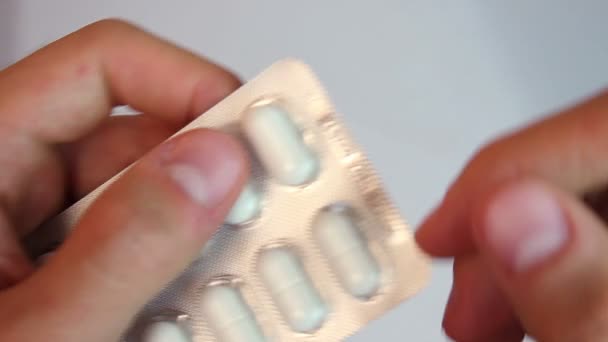 Schüttelnde Hände nehmen Pille aus Packung — Stockvideo