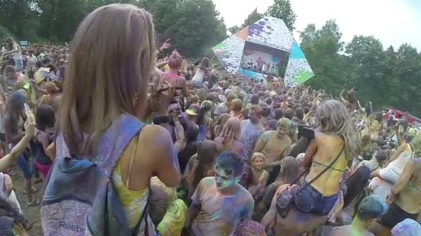 Девушка сидит на плечах своего парня на фестивале — стоковое видео