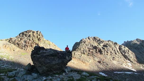 Hombre meditando en la roca — Vídeo de stock