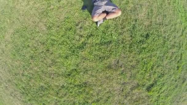 Gelukkig man liggen op gras — Stockvideo