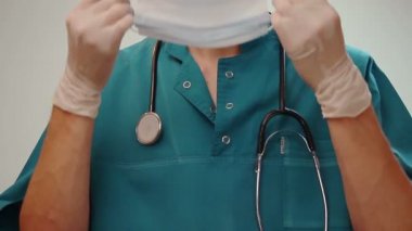 Beyaz eldiven cerrahi maske koyar